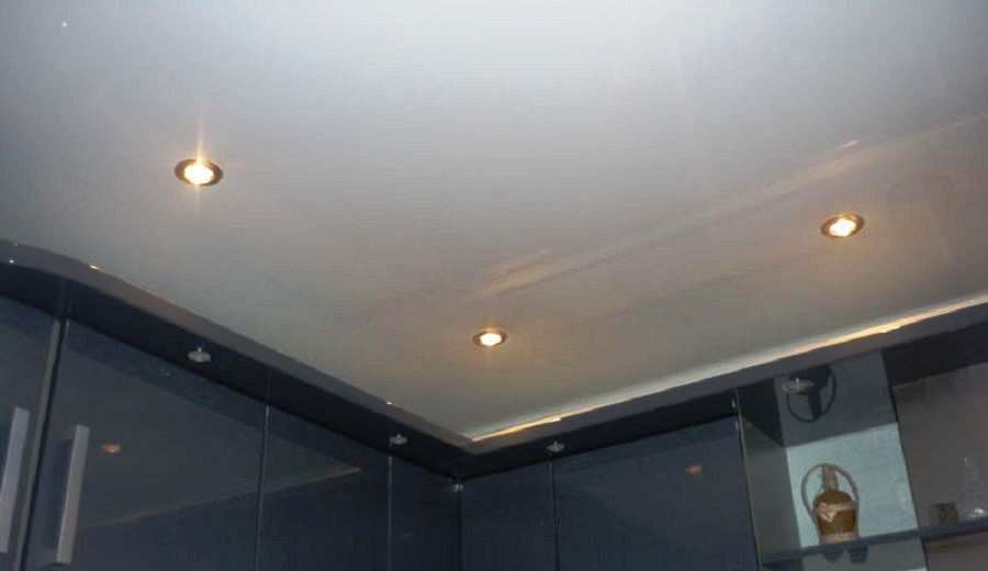 Глянцевый натяжной потолок с точечными светильниками на кухне