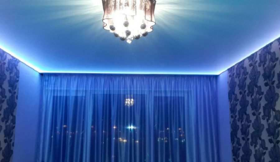 Фотография натяжного потолка с синей подсветкой в зале