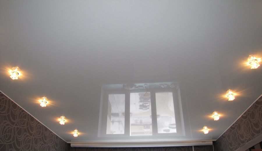 Фотография глянцевого натяжного потолка белого цвета с точечными светильниками